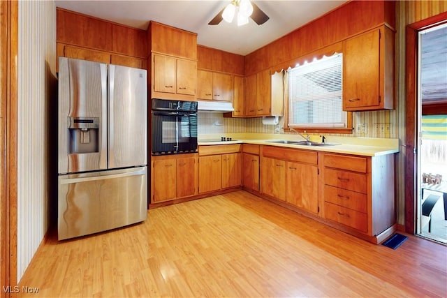 2455 Alexander Mnr E, Steubenville, OH 43952 - kitchen with black appliances, a sink, under cabinet range hood, light countertops, and light wood-style flooring