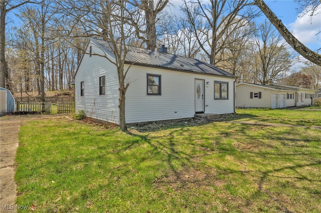 back of house with metal roof and an outdoor structure
