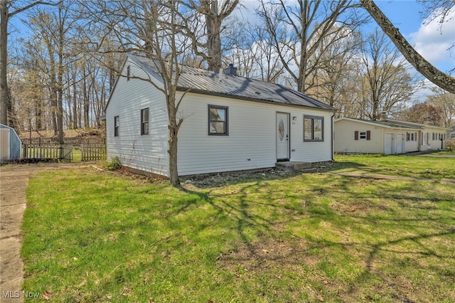 back of house with metal roof and an outdoor structure