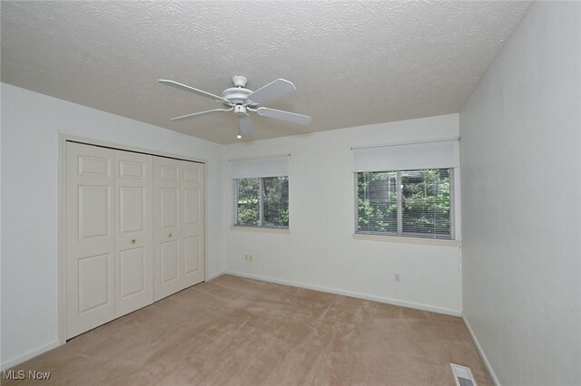 4212 Castle Rdg, Copley, OH 44321 - unfurnished bedroom featuring light colored carpet, a closet, baseboards, a textured ceiling, and a ceiling fan