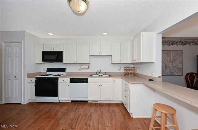 4212 Castle Rdg, Copley, OH 44321 - kitchen with range with gas cooktop, dishwasher, black microwave, a sink, and white cabinetry