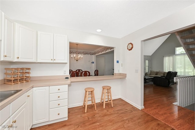 4212 Castle Rdg, Copley, OH 44321 - kitchen with a chandelier, white cabinets, light wood-style flooring, light countertops, and baseboards