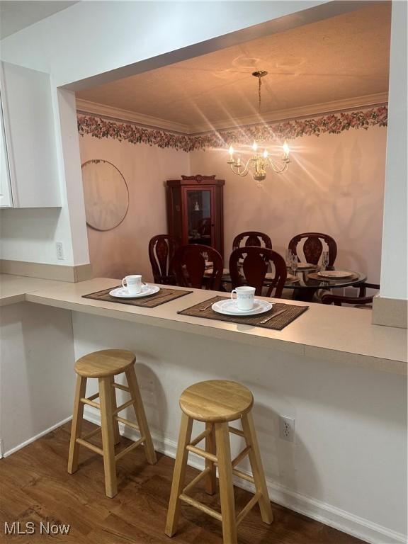 4212 Castle Rdg, Copley, OH 44321 - dining area featuring crown molding, wood finished floors, and a chandelier