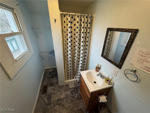 871 Chestnut St, Coshocton, OH 43812 - bathroom featuring a stall shower, baseboards, vanity, stone finish flooring, and a spacious closet