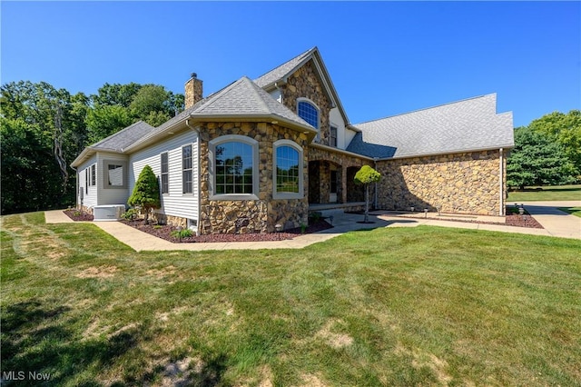 6240 Tim Dr, Wadsworth, OH 44281 - view of front facade featuring stone siding, a chimney, a front lawn, and roof with shingles