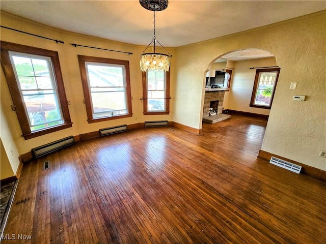 105 W 40th St, Shadyside, OH 43947 - unfurnished dining area featuring a baseboard heating unit, hardwood / wood-style flooring, baseboards, a fireplace with raised hearth, and a textured wall