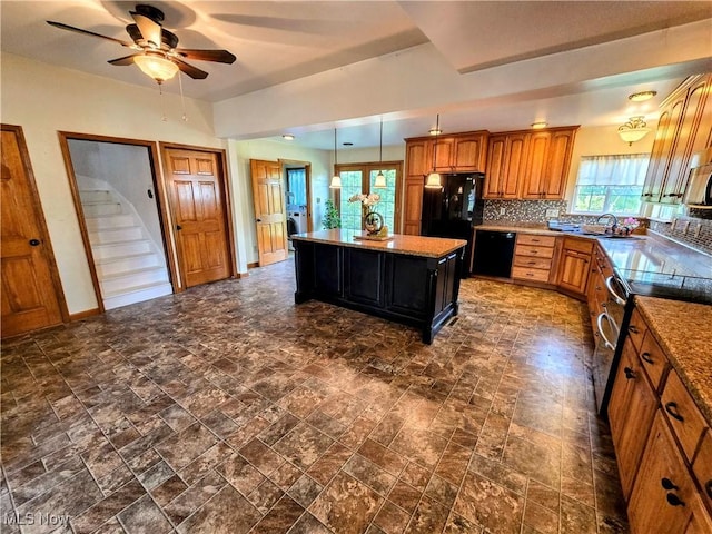 105 W 40th St, Shadyside, OH 43947 - kitchen with black appliances, ceiling fan, a center island, brown cabinets, and backsplash