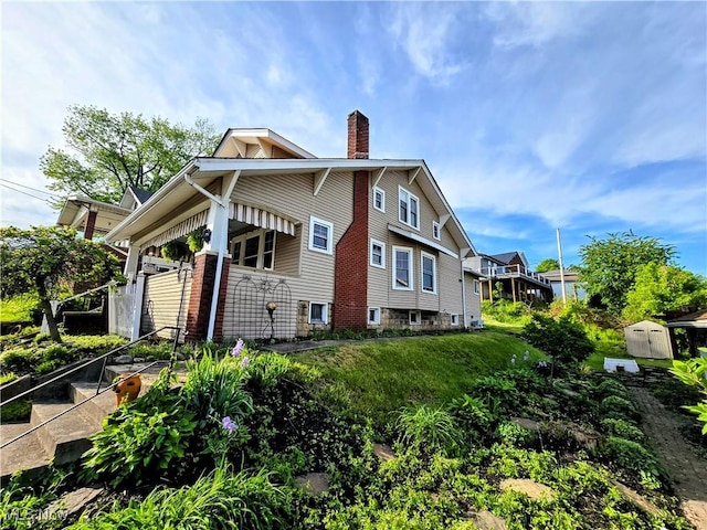 105 W 40th St, Shadyside, OH 43947 - view of property exterior with a chimney, a storage unit, and an outdoor structure