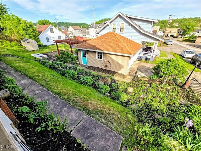 105 W 40th St, Shadyside, OH 43947 - view of home's exterior with a shed, an outdoor structure, fence, a residential view, and a pergola