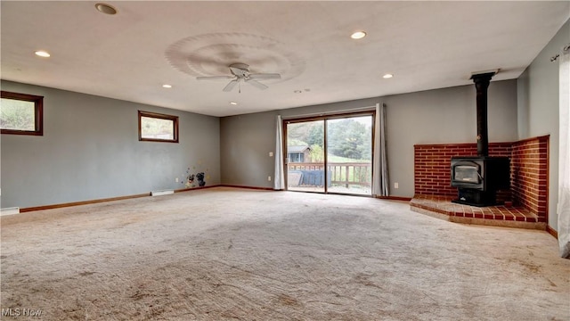 6456 Dover Zoar Rd NE, Dover, OH 44622 - unfurnished living room with carpet, a wood stove, baseboards, recessed lighting, and a ceiling fan