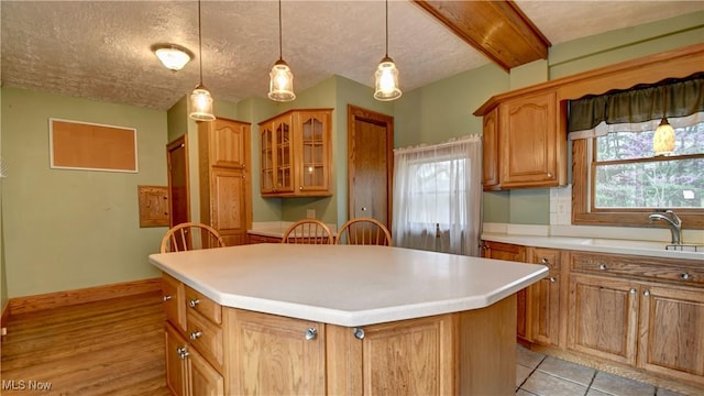 6456 Dover Zoar Rd NE, Dover, OH 44622 - kitchen with a sink, a center island, glass insert cabinets, a textured ceiling, and light countertops