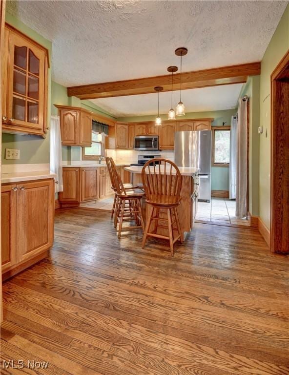 6456 Dover Zoar Rd NE, Dover, OH 44622 - dining area with a textured ceiling, wood finished floors, beam ceiling, plenty of natural light, and baseboards
