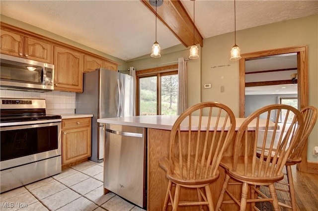 6456 Dover Zoar Rd NE, Dover, OH 44622 - kitchen with appliances with stainless steel finishes, light countertops, decorative backsplash, a kitchen breakfast bar, and beam ceiling