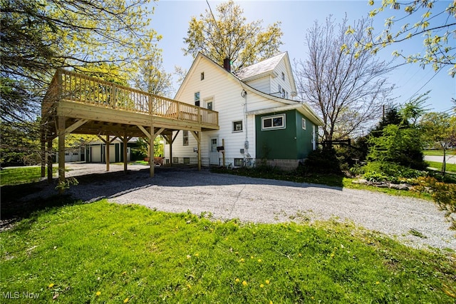2226 W 13th St, Ashtabula, OH 44004 - back of property with driveway, a deck, a carport, an outbuilding, and a chimney