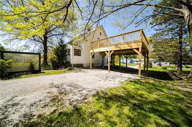 2226 W 13th St, Ashtabula, OH 44004 - back of house featuring a wooden deck, gravel driveway, and a lawn