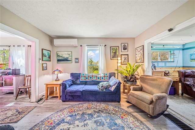 2226 W 13th St, Ashtabula, OH 44004 - living room featuring a wall mounted AC, wood finished floors, a textured ceiling, and baseboards