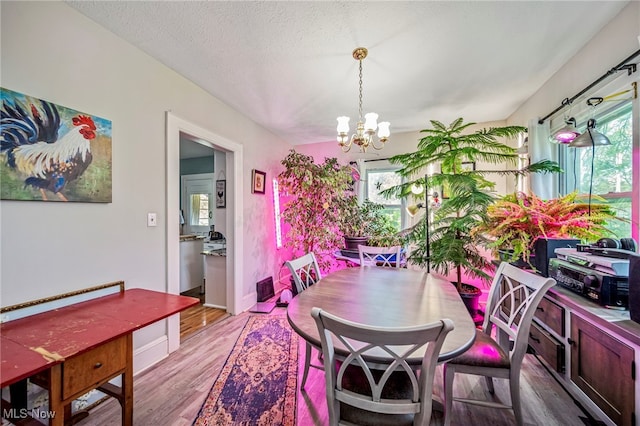 2226 W 13th St, Ashtabula, OH 44004 - dining space featuring plenty of natural light, a chandelier, light wood finished floors, and a textured ceiling