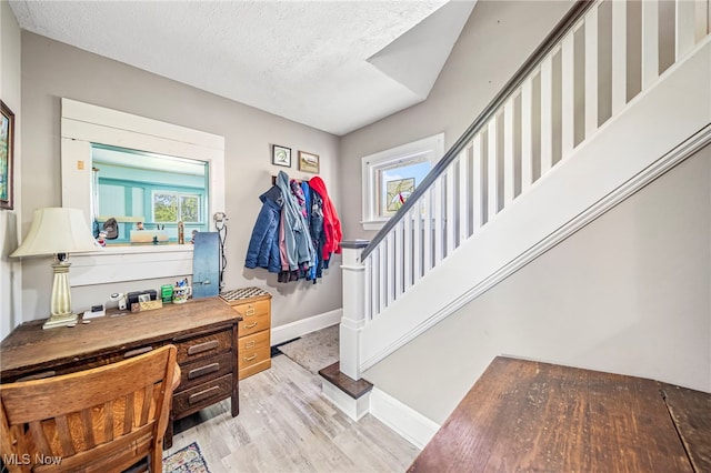 2226 W 13th St, Ashtabula, OH 44004 - entrance foyer with baseboards, wood finished floors, plenty of natural light, stairs, and a textured ceiling