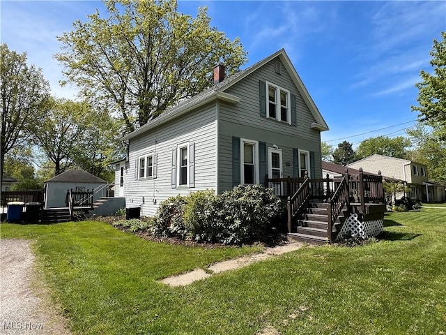 2640 W 19th St, Ashtabula, OH 44004 - view of side of property with a deck, a chimney, a yard, an outbuilding, and a storage shed