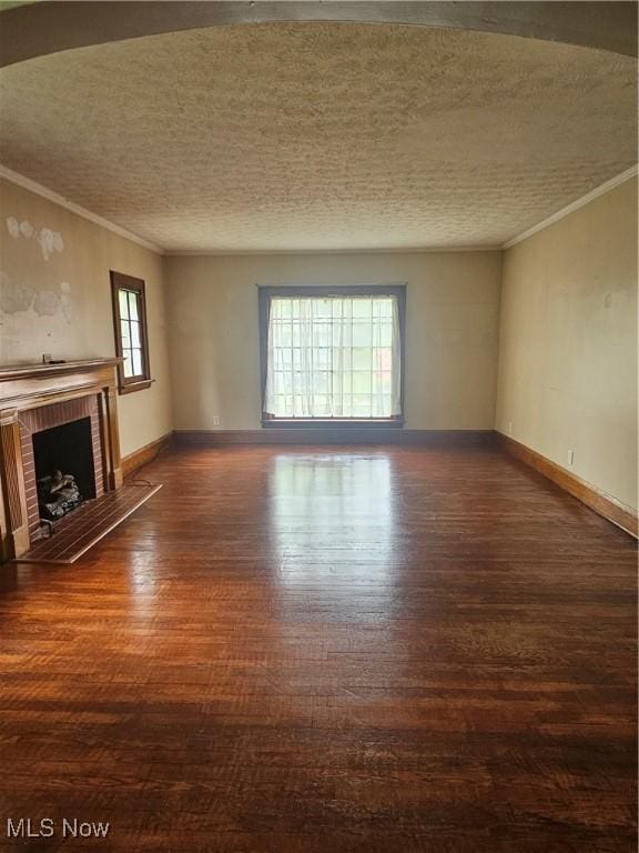 825 Summit St, Salem, OH 44460 - unfurnished living room featuring crown molding, wood finished floors, a brick fireplace, baseboards, and a textured ceiling
