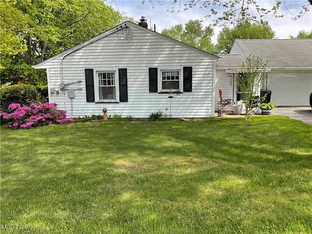 view of front of house featuring a garage, a chimney, and a front lawn