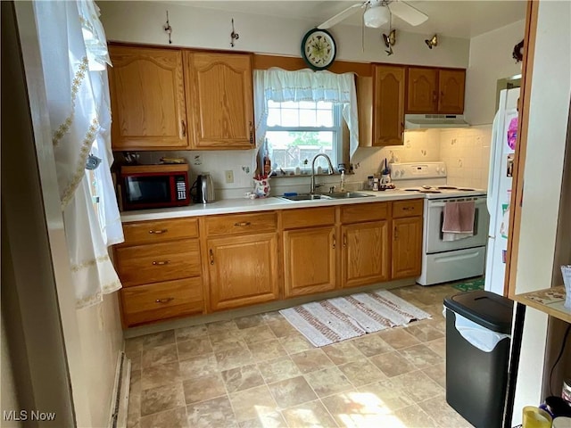 kitchen featuring white appliances, a sink, under cabinet range hood, light countertops, and a ceiling fan
