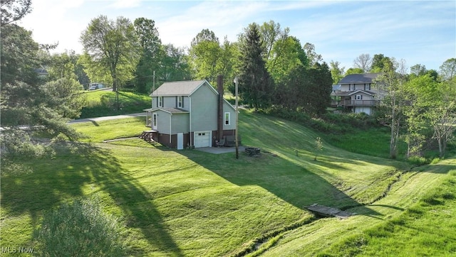 59969 Somerton Hwy, Barnesville, OH 43713 - view of green lawn featuring an attached garage, driveway, and view of scattered trees