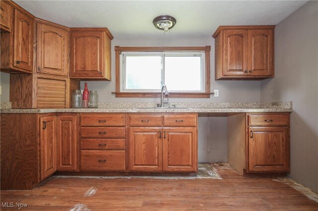 59969 Somerton Hwy, Barnesville, OH 43713 - kitchen with a sink, brown cabinetry, wood finished floors, and light countertops