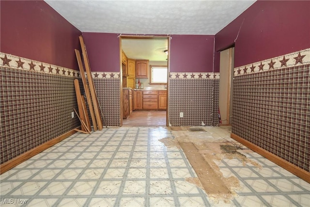 59969 Somerton Hwy, Barnesville, OH 43713 - unfurnished bedroom featuring tile walls, a wainscoted wall, and a textured ceiling