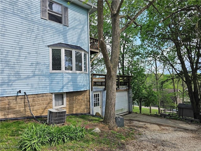 164 W High St, New Concord, OH 43762 - view of side of home featuring central AC unit, driveway, a garage, and a wooden deck