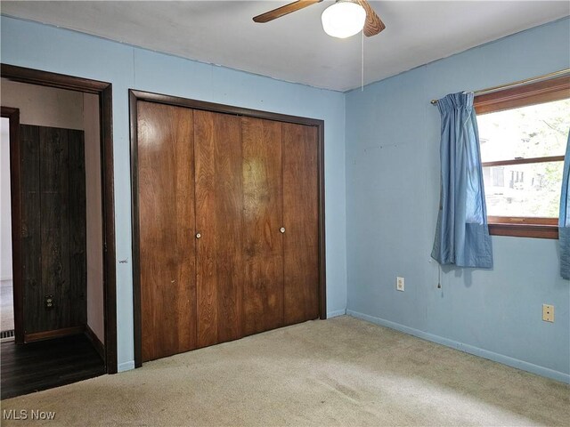 164 W High St, New Concord, OH 43762 - unfurnished bedroom featuring carpet flooring, a ceiling fan, and a closet