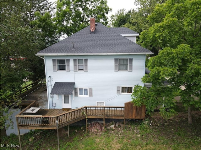 164 W High St, New Concord, OH 43762 - back of property with roof with shingles, a chimney, a wooden deck, and view of scattered trees