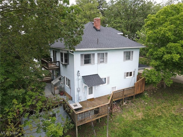 164 W High St, New Concord, OH 43762 - back of property featuring roof with shingles, a chimney, a deck, and view of wooded area