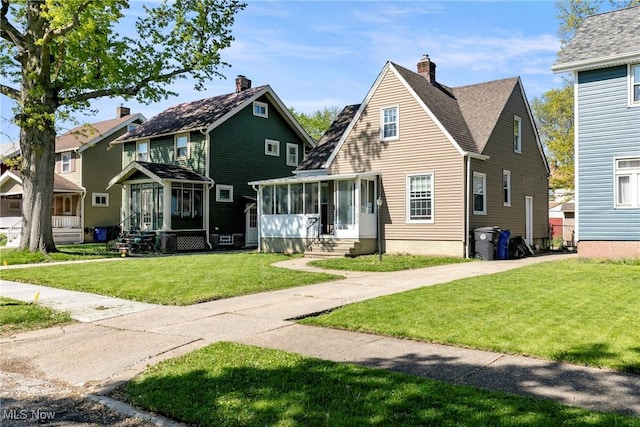 4414 W 171st St, Cleveland, OH 44135 - view of front facade featuring a sunroom, a front lawn, entry steps, and a chimney