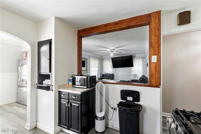 4414 W 171st St, Cleveland, OH 44135 - kitchen featuring dark cabinets, ceiling fan, freestanding refrigerator, arched walkways, and light countertops