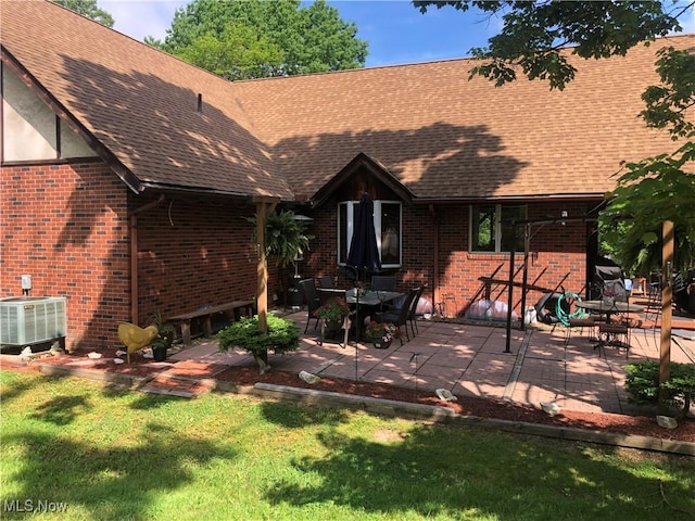 359 Boyce Dr, Chester, WV 26034 - rear view of house featuring cooling unit, brick siding, a shingled roof, a lawn, and a patio area