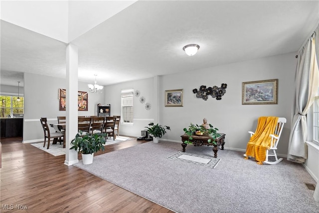 living area with a chandelier, wood finished floors, and baseboards