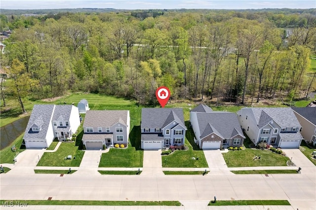 aerial perspective of suburban area featuring a heavily wooded area