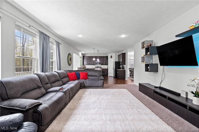 living area with recessed lighting and dark colored carpet