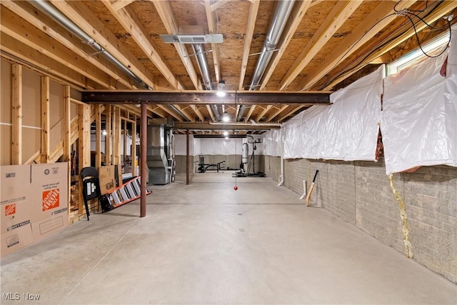 unfinished below grade area featuring drainage system and heating unit