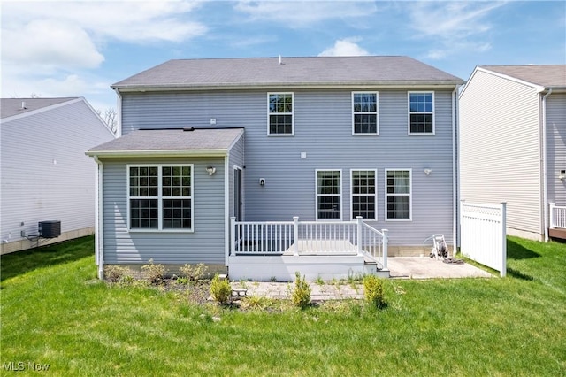 rear view of property featuring a patio, a yard, and a deck