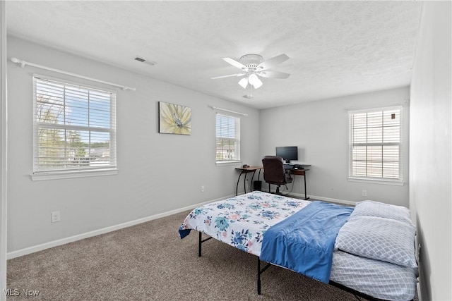 carpeted bedroom with baseboards, a textured ceiling, and a ceiling fan