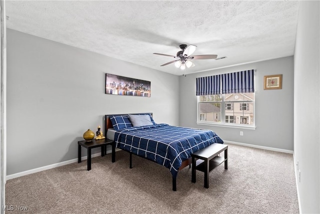 bedroom with carpet flooring, a textured ceiling, baseboards, and a ceiling fan