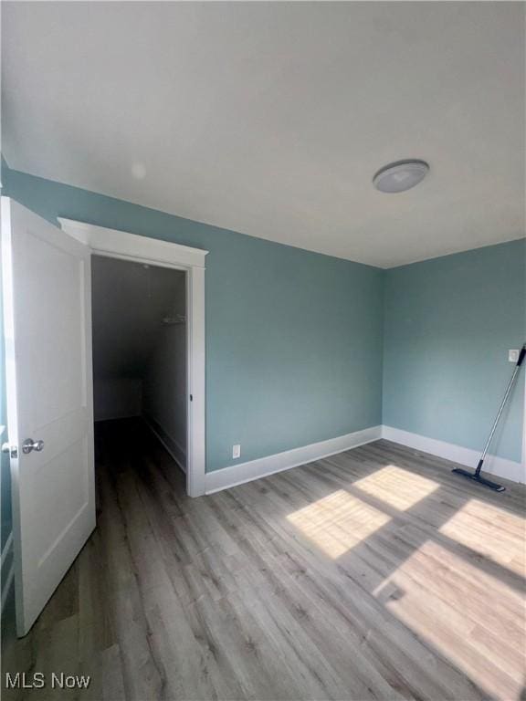 510 Parkcliffe Ave, Youngstown, OH 44511 - unfurnished bedroom featuring wood finished floors, baseboards, and a walk in closet