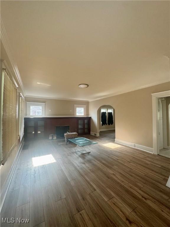 510 Parkcliffe Ave, Youngstown, OH 44511 - unfurnished living room with wood finished floors, arched walkways, crown molding, baseboards, and plenty of natural light