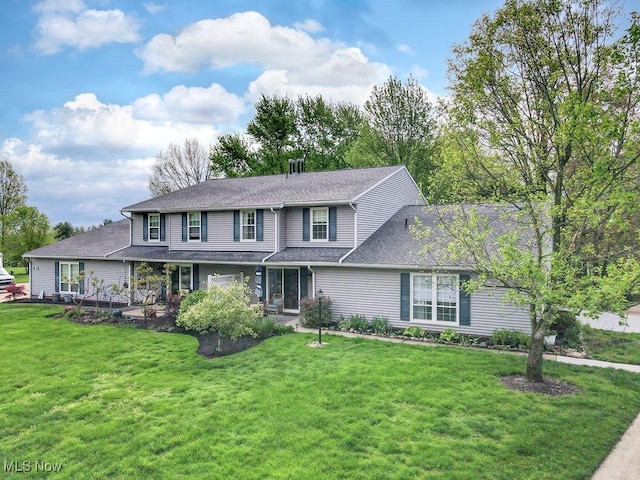 view of front of house with a front yard and a shingled roof
