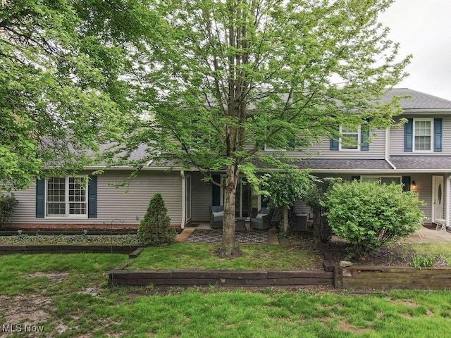 view of front of home with a front yard and a patio area
