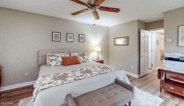 bedroom with light wood-type flooring, baseboards, ceiling fan, and ornamental molding