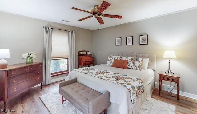 bedroom with light wood-style flooring, baseboards, and a ceiling fan
