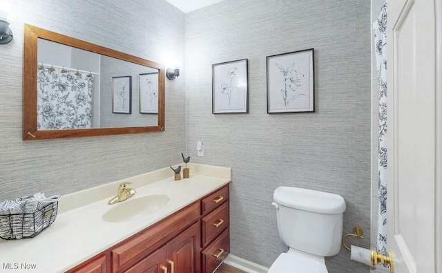 bathroom featuring vanity, toilet, and a shower with shower curtain
